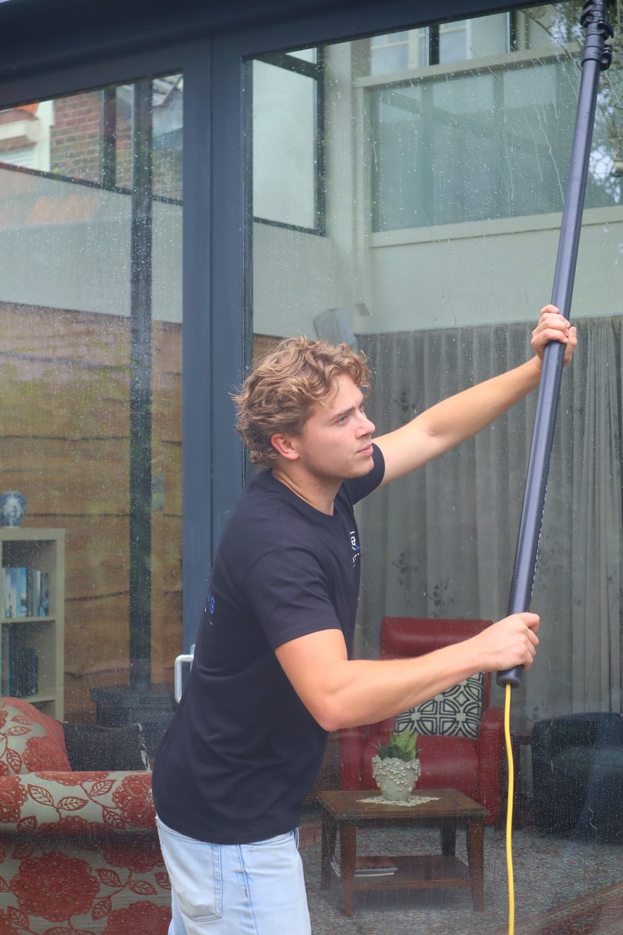 Blitzglas wast de ramen met een waterfed pole en zuiver water
